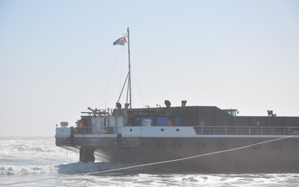 Crew visible on the stranded barge Manahau.