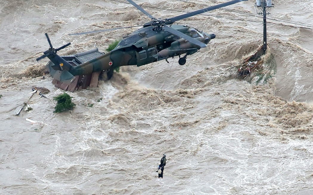 A local resident is rescued by a helicopter of the Gound Self Defense Force in a flooded area in Joso.