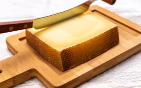 Block of Swiss medium-hard matured cheese gruyere used for baking, quiche, fondue, sandwiches  close up