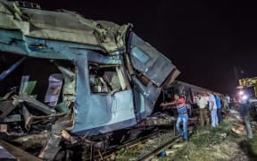 Emergency personnel and Egyptian military police search the wreckage of the train collision.