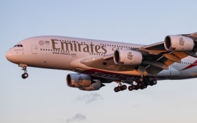 Emirates Airbus A380 shown landing at London Heathrow International Airport LHR / EGLL in England, UK over the residential area of Myrtle Avenue.