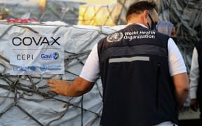 An employee of the World Health Organisation (WHO) supervises the arrival of the first batch of coronavirus vaccines, at Khartoum airport in the Sudanese capital, on 3 March 2121.