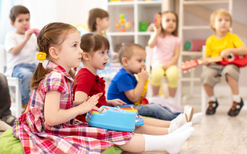 Group of kids 3-4 years old with toy musical instruments. Early music education in kindergarten