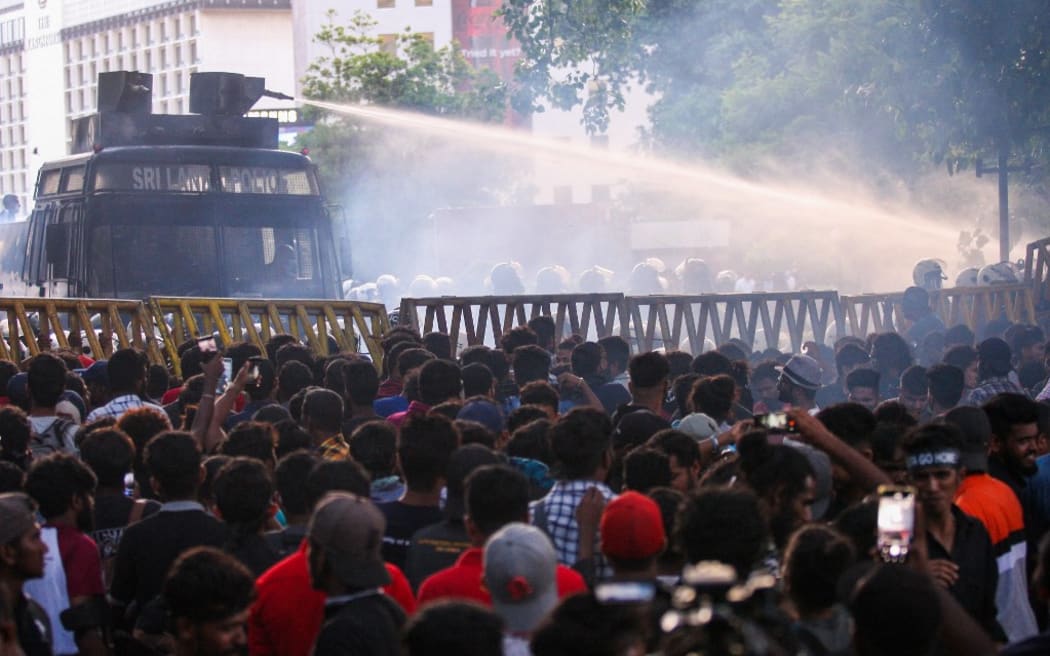 Police use a water canon to disperse demonstrators taking part in an anti-government protest demanding the resignation of Sri Lanka's President Gotabaya Rajapaksa over the country's crippling economic crisis, in Colombo on July 8, 2022. (Photo by AFP)