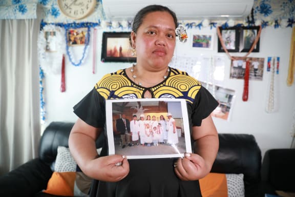 Nu'ulua Fa'aofo stands in her Kelston home holding a photo of her family after her husband, Uili Fa'aofo was killed in a car crash at Ramarama on Monday.