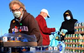 Volunteers prepare food assistance for the needy at the Share Your Christmas food distribution event sponsored by the Second Harvest Food Bank of Central Florida, Faith Neighborhood Center, and WESH 2 at Hope International Church on December 9, 2020 in Groveland, Florida, near Orlando.
