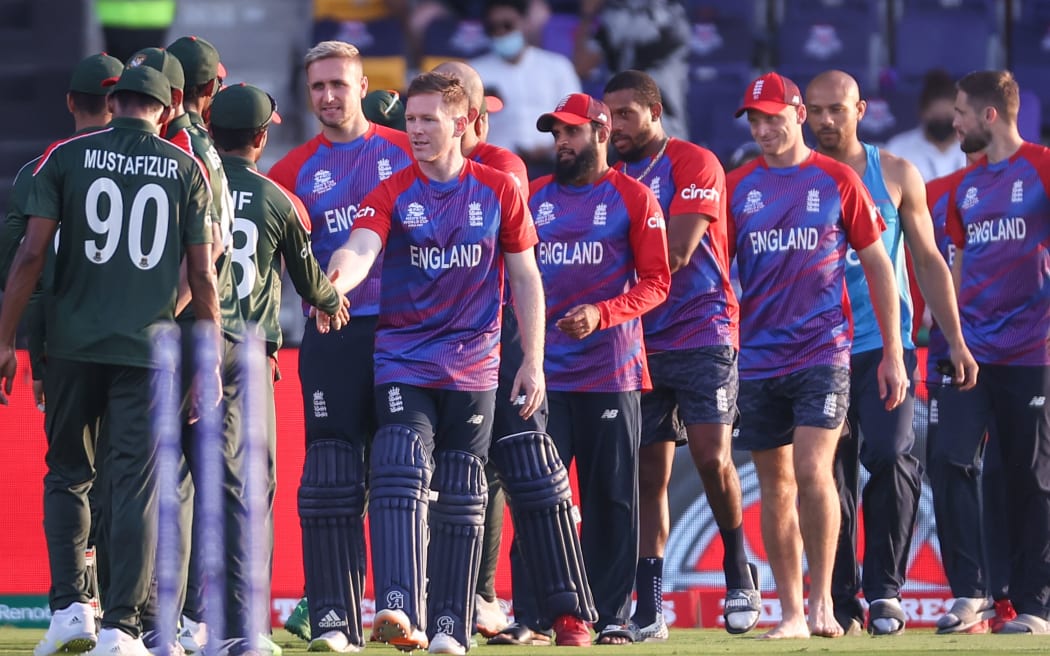 England's captain Eoin Morgan shakes hands with players from Bangladesh.