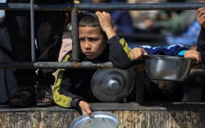 Displaced Palestinians gather to receive food at a donation point in Rafah in the southern Gaza Strip on March 07, 2024, after more than four months of ongoing battles between Israel and the militant group Hamas. UNICEF, the UN Children's Agency, and the UN's World Food Programme have warned Gazans are inching closer towards famine.