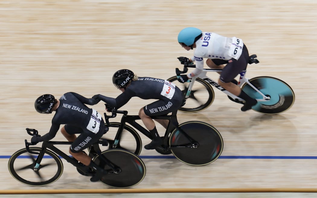 New Zealand's Bryony Botha relays New Zealand's Emily Shearman during the women's track cycling madison final of the Paris 2024 Olympic Games at the Saint-Quentin-en-Yvelines National Velodrome in Montigny-le-Bretonneux, south-west of Paris, on August 9, 2024. (Photo by Thomas SAMSON / AFP)