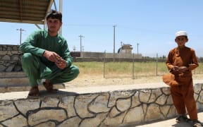 Youths pose for a picture outside Bagram Air Base, after all US and NATO troops left, some 70 Km north of Kabul on July 2, 2021. (Photo by Zakeria HASHIMI / AFP)