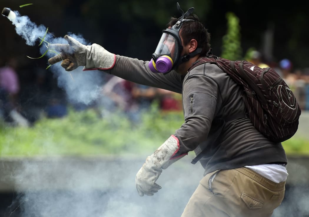 A man clashes with policemen during a protest against new emergency powers decreed this week by President Nicolas Maduro in Caracas on May 18, 2016.
