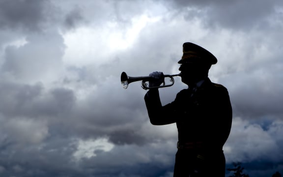 Silhouette of a man playing taps on his bugle at a veterans funeral at Medical Lake Veterans Memorial in Washington.