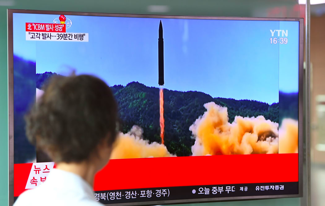 A woman walks past a television screen in the South Korean capital Seoul showing a picture of North Korea's launch of an intercontinental ballistic missile.