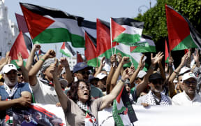 Moroccans chant slogans and wave the Palestinian flag during a march to express their solidarity with the Palestinians in the Gaza Strip, in Rabat on July 19, 2025.