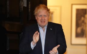 Boris Johnson participates in a national 'clap for carers' in the doorway of 10 Downing Street on April 2, 2020.