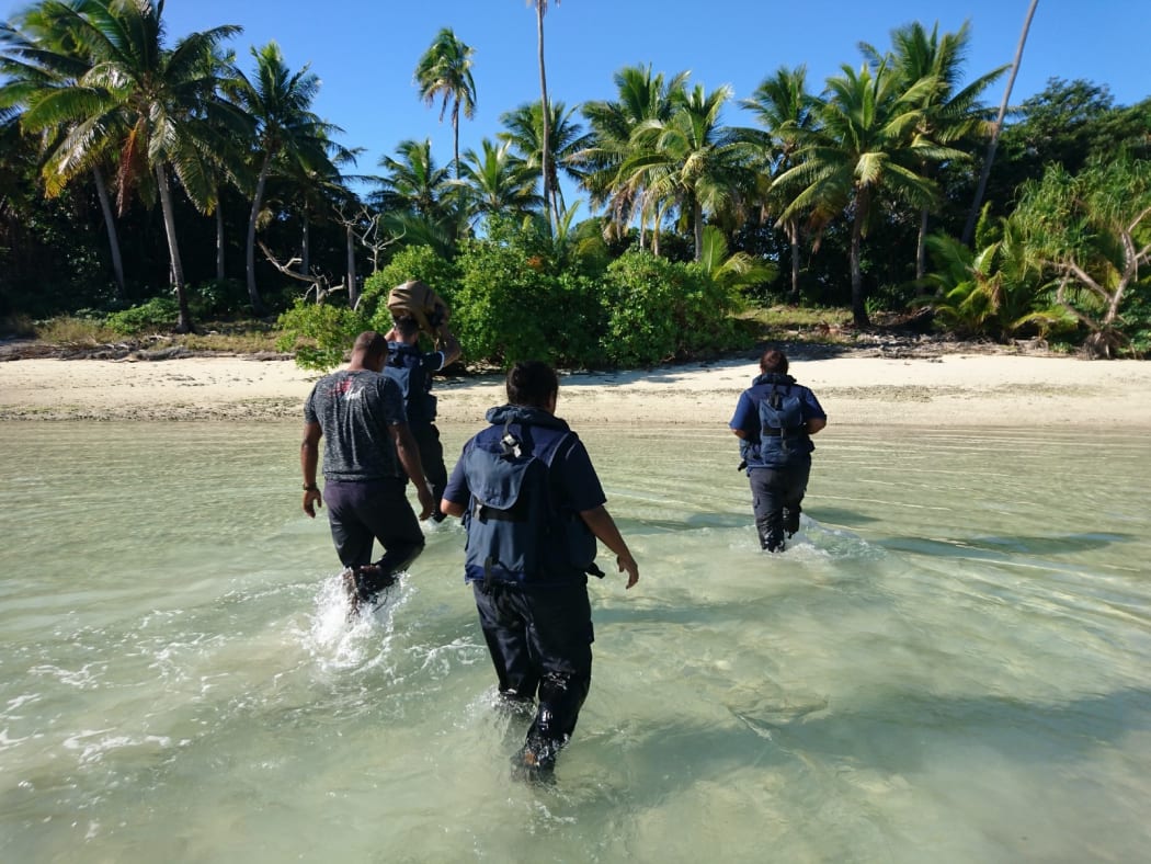 Crew members from Royal New Zealand Navy inshore patrol vessel HMNZS Taupo and personnel from Fiji Revenue and Customs Service wade towards the remote island where over 12 kgs of cocaine were found last week.