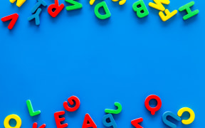 Alphabet for kids concept. English letters in disorder on blue background top view.