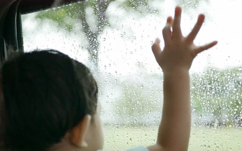 A toddler looking out the window.