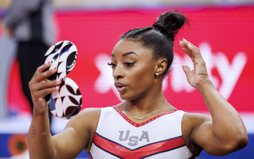 US gymnast Simone Biles looks at herself in a mirror during the 2024 US Olympic Gymnastics Trials.