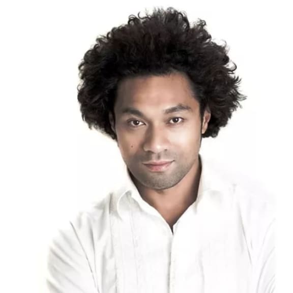 Sani Muliaumaseali'i head and shoulders, arms crossed looking at camera.