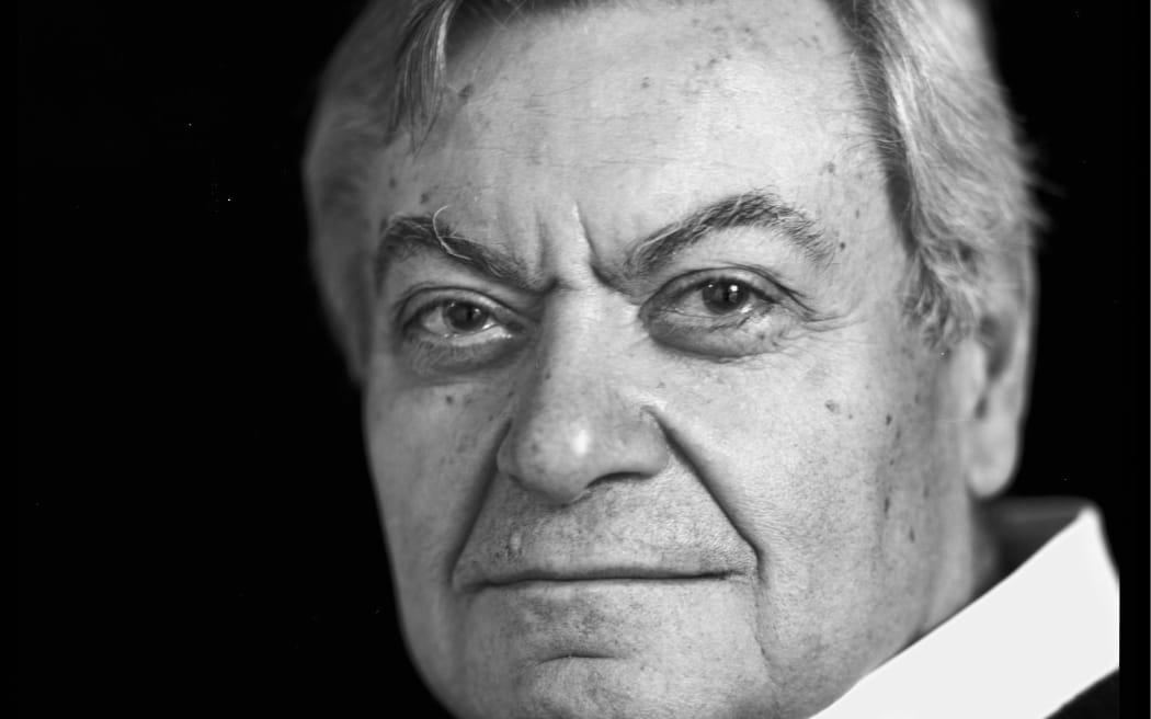 Head and shoulders and black and white image of man with white shirt  and black jumper