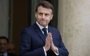 France's President Emmanuel Macron gestures as he waits for Romania's interim President for talks at the Elysee presidential Palace in Paris on February 19, 2025, one day after a meeting with seven European countries, focused on Ukraine, in the belief that ‘Russia is an existential threat’ to the continent. After bringing together the heavyweights of the European Union, Emmanuel Macron will have spoken to the 27 Member States by the end of the week. (Photo by Ludovic MARIN / AFP)