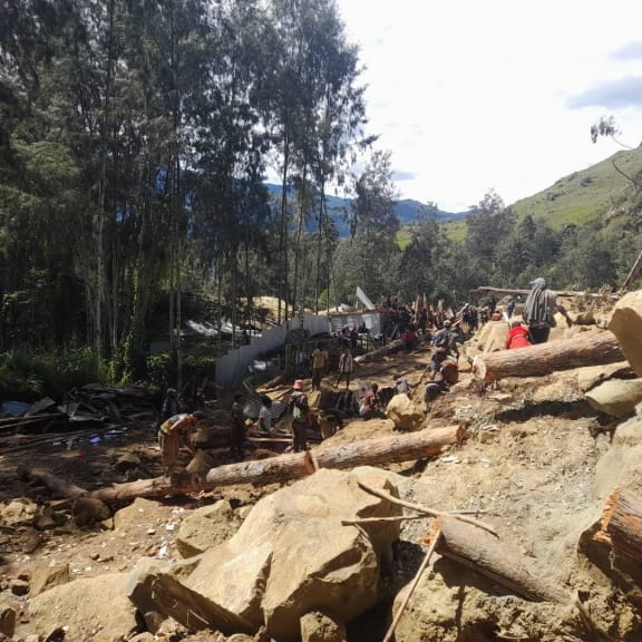 People dig through mud and rocks on 28 May, 2024, after a major landslide in Yambali village in Enga province, Papua New Guinea.