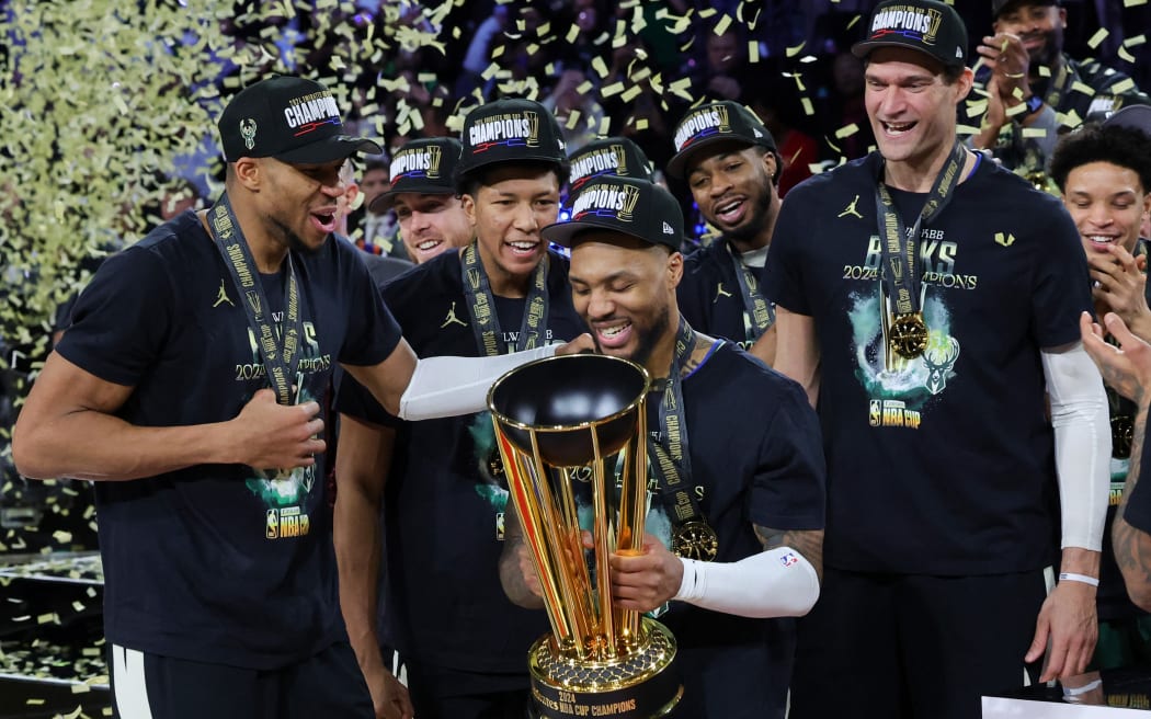 Giannis Antetokounmpo #34, MarJon Beauchamp #3, Damian Lillard #0 and Brook Lopez #11 of the Milwaukee Bucks celebrate with the championship trophy after the Bucks defeated the Oklahoma City Thunder 97-81 to win the championship game of the Emirates NBA Cup.