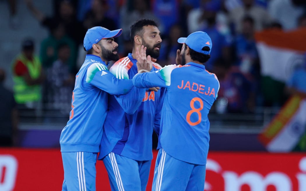 Varun Chakravarthy of India (C) celebrates the wicket of Glenn Phillips of New Zealand during their Champions Trophy pool match in Dubai.