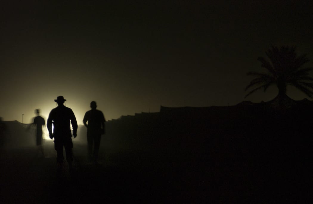 CAMP SATHER, Iraq -- Airmen from the 447th Air Expeditionary Group here walk among tents during blackout conditions.  After a bombing in nearby Baghdad, the camp located at Baghdad International Airport was bathed in darkness as a force protection measure.
