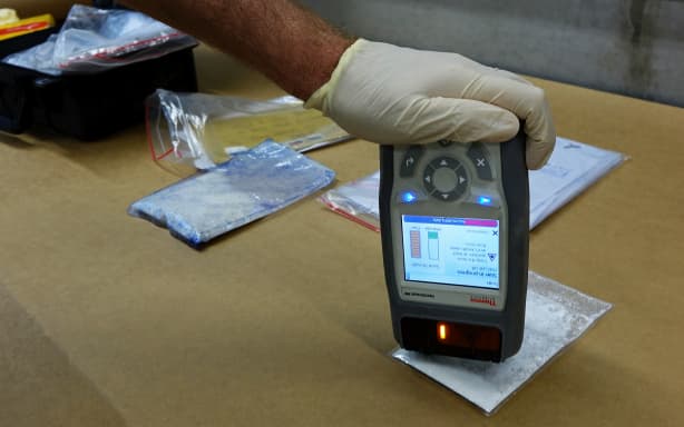 A customs official does a quick test for illicit drugs using the “First Defender” tool - which is a small device that can check for thousands of narcotics in seconds