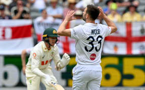 England’s Mark Wood reacts after Australia’s Brendan Doggett hits a shot during the first Ashes Test, Perth, 2025.