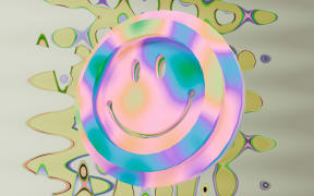 A colourful smiley face floats in a trippy colourful backgrtound.