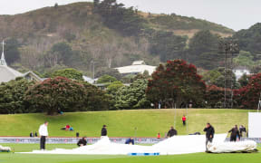 Groundsmen pull the rain covers on to the Basin Reserve.