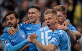 Manchester City players celebrate with Kevin De Bruyne and Oleksandr Zinchenko.