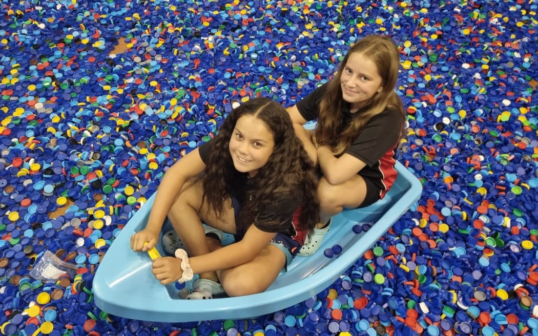 Elliot Chadwick and Emma Smith of Stratford Primary School afloat on a sea of lids