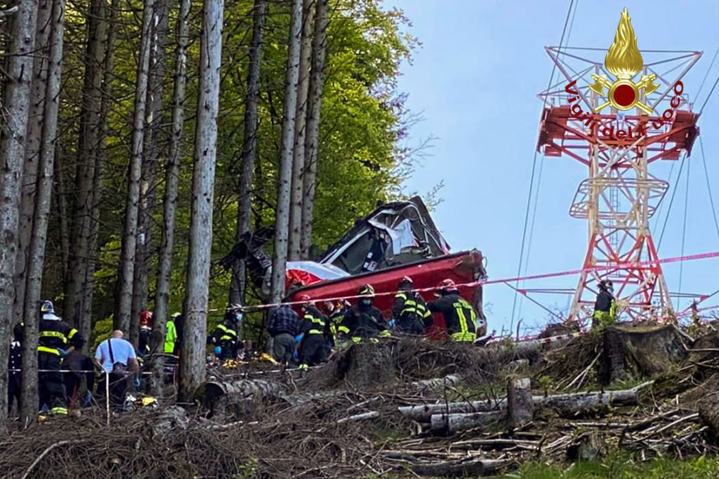 A photo taken and handout on May 23, 2021 by The Italian Firefighters "Vigili del Fuoco" shows rescuers working by a cable car that crashed to the ground in the resort town of Stresa on the shores of Lake Maggiore in the Piedmont region.