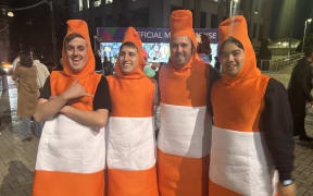 Four men dressed as roadcones.