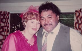 Archival photo of two young people, a woman (Suzanne Young) and a man (Darcy Te Hira). Suzanne wears a fuschia colours dress and Darcy wears a grey suit vest and white shirt.
