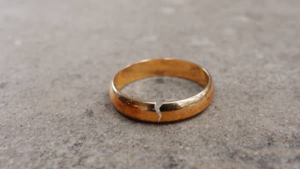 A gold wedding ring with a crack in it.