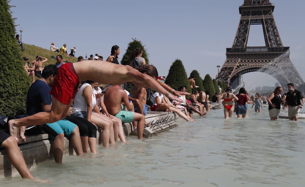 A boy jumps into the water of the Trocadero Fountain in Paris during a heatwave on June 28, 2019.