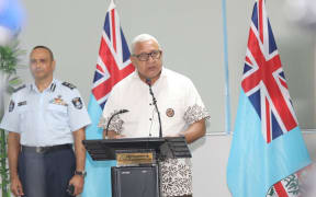 Fiji's PM, Frank Bainmarama gives a Covid-19 update, with Police Commissioner Sitiveni Qiliho behind him