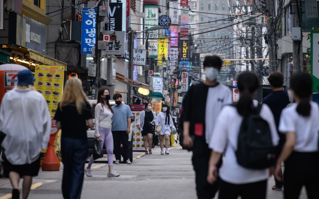 Pedestrians wearing face masks walk on a street in Seoul on August 24, 2020