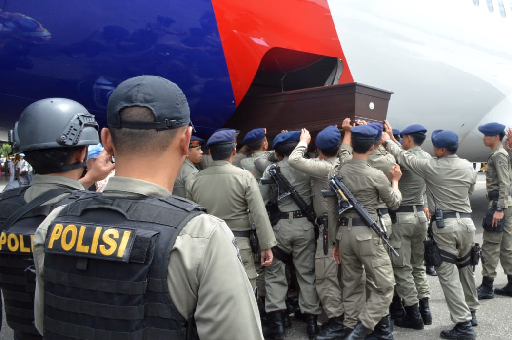 Indonesian police load a coffin bearing the body of a slain policeman Timika airport in remote eastern province of Papua on January 2, 2015. Three security personnel were found dead at the Freeport mine in eastern Indonesia.