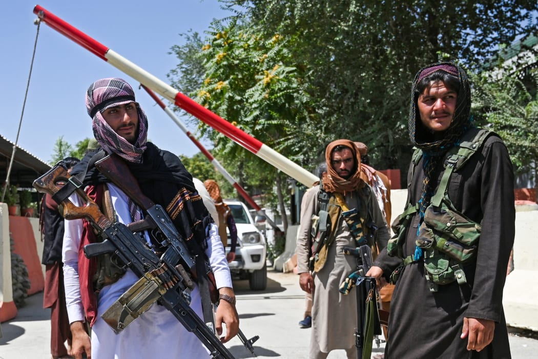 Taliban fighters stand guard along a roadside near the Zanbaq Square in Kabul on August 16