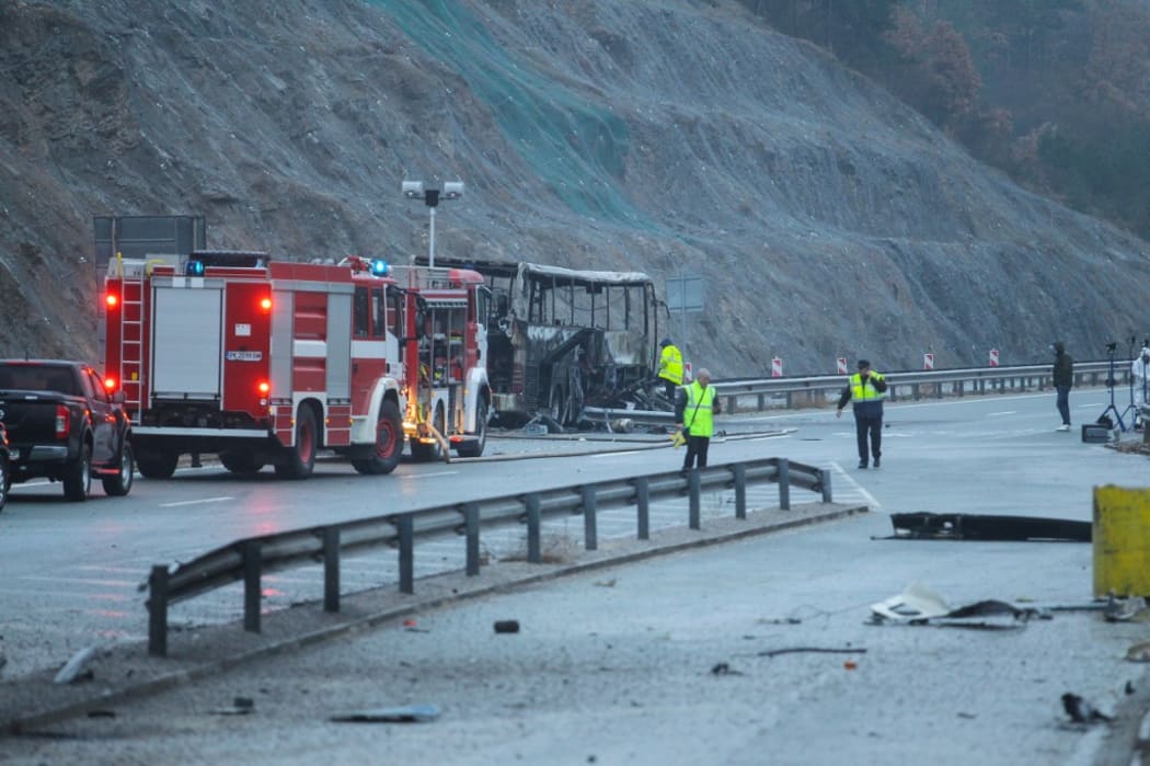 Officials work at the site of a bus accident, in which at least 45 people were killed, on a highway near the village of Bosnek, south of Sofia, on November 23, 2021.