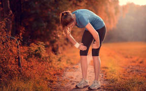 Young athletic woman taking a break from training standing resting, fatigue.