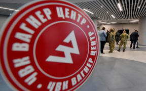 Visitors wearing military camouflage stand at the entrance of the 'PMC Wagner Centre', associated with the founder of the Wagner private military group (PMC) Yevgeny Prigozhin, during the official opening of the office block on the National Unity Day, in Saint Petersburg, on November 4, 2022.