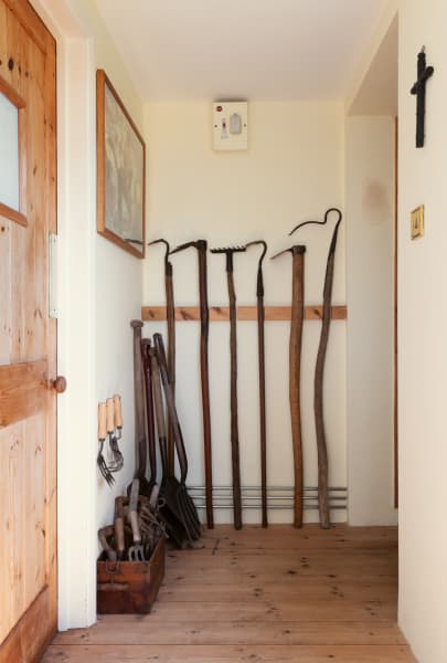 Tools are displayed along the corridor and in the entranceway to the garden room. Jarman had his favourite hoe, its head worn down from use in the shingle, cast in bronze by Peter Fillingham.