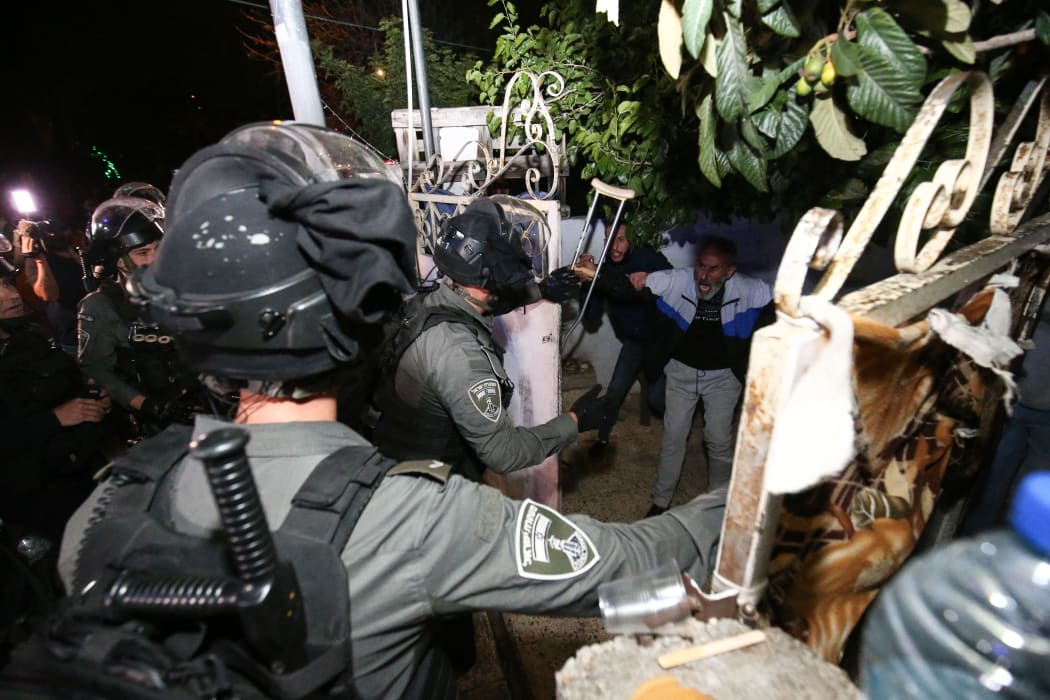 Israeli forces force a door of a Palestinian family to raid the house as Palestinians gather to stage a demonstration at Sheikh Jarrah neighborhood after Israeli government's plan to force some Palestinian families out of their homes in East Jerusalem on May 06, 2021.